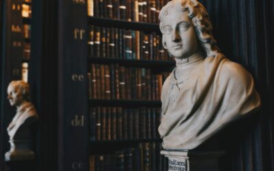 figurine de buste d'homme portant une robe près d'un mur noir