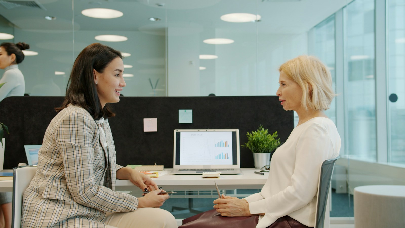 Two women talking in a modern office setting